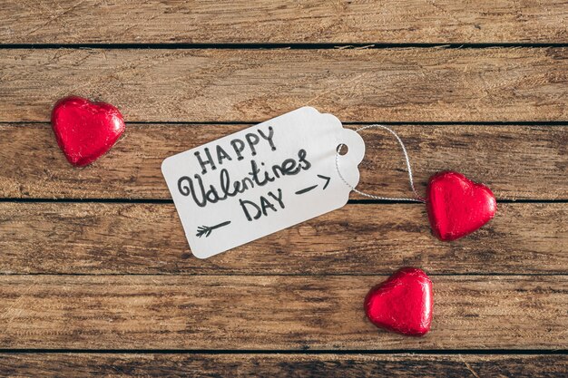 Gift tag with the inscription happy valentines day and heartshaped candies