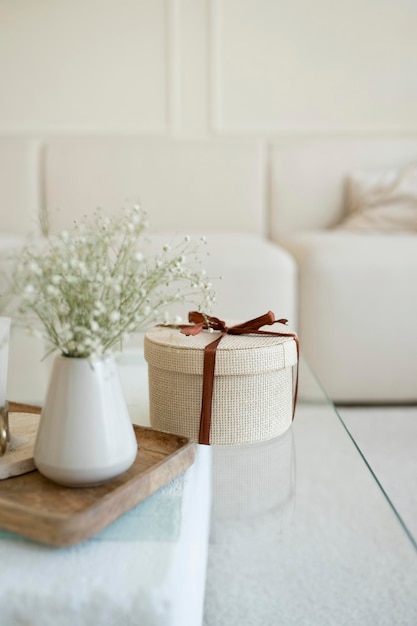 A gift with a red ribbon on a glass table in the interior