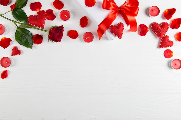 Gift with red ribbon, red rose and heart on white background