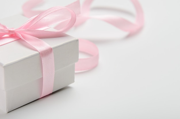 A gift for a woman in white box with a pink ribbon. 
