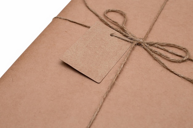 A gift wrapped in paper with a postcard for a message isolated on a white background