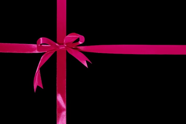 Photo gift wrapping design with pink ribbons and bow isolated on black background