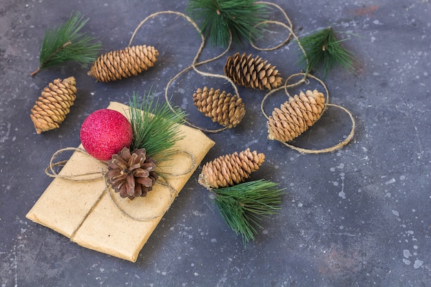 Gift wrapping in kraft paper with christmas decoration on a dark background