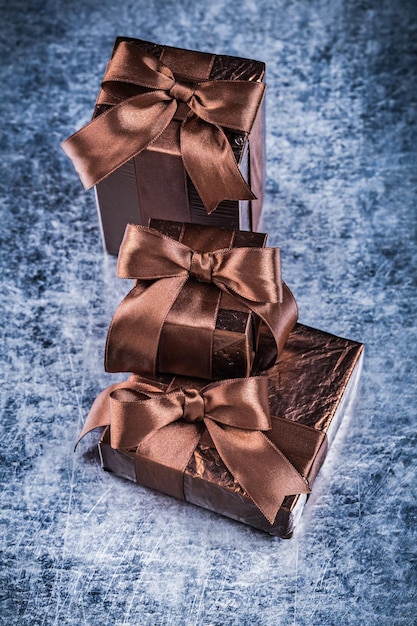 Фото Подарочные коробки, упакованные в мятую блестящую бумагу на поцарапанном металлическом фоне