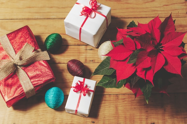 Giftboxes and poinsettia on wooden table