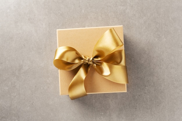 Giftdoos met gouden lint op grijze achtergrond