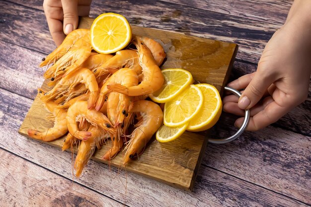 Gifted shrimps and sliced lemon are laid out on a wooden stand