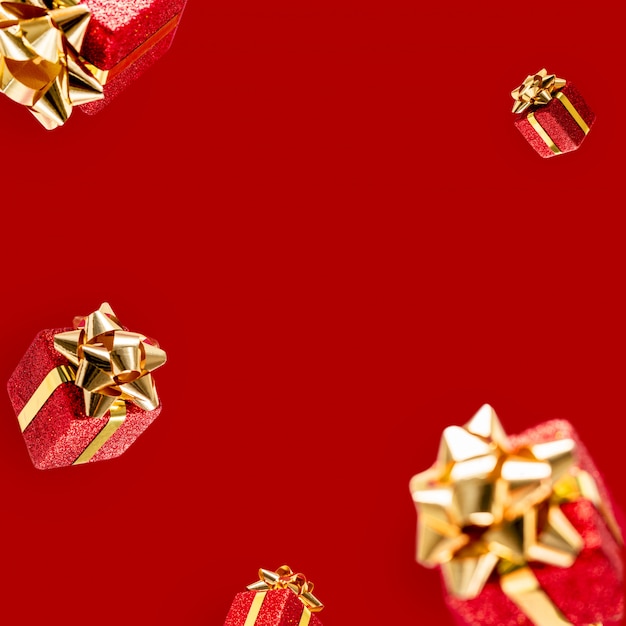 Gifts are flying in the air on a red background. Sale. Levitation concept. Christmas layout with copy space.