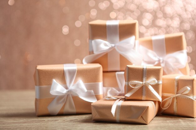 Подарки в золотой упаковке на цветном фоне с местом для текста
