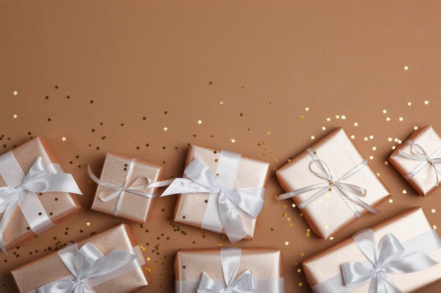 Gifts in gold packaging on a colored background with place for text