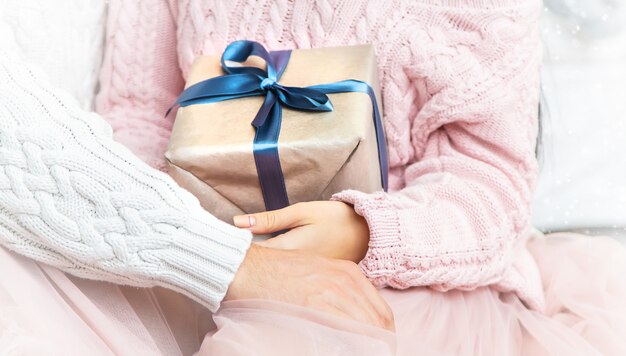 Gifts in the hands of a man and a woman. Selective focus.