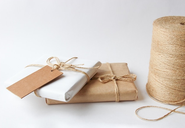 Gifts in kraft paper tied with rope on a light background