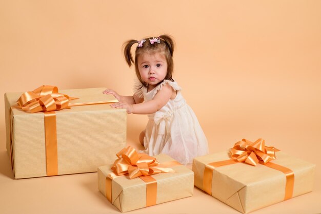 Gifts. Little cute girl with present box. Holidays celebration.