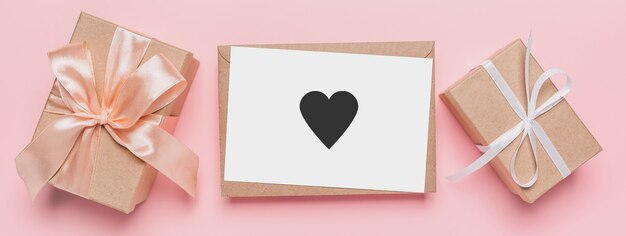 Gifts with note letter on isolated pink background, love and valentine concept with heart