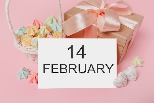 Gifts with note letter on isolated pink background with sweets, love and valentine concept with text 14 february