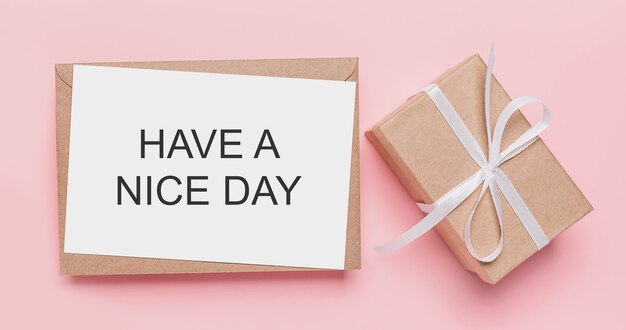 Подарки с запиской на изолированной розовой поверхности с текстом HAVE A NICE DAY