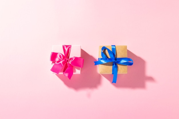 Gifts with a ribbon on a pink background under natural light. Modern.  holiday, family, beloved, for him. Banner. Flat lay, top view