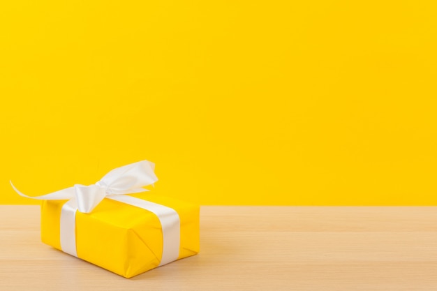 Подарки с лентами на ярко-желтом фоне