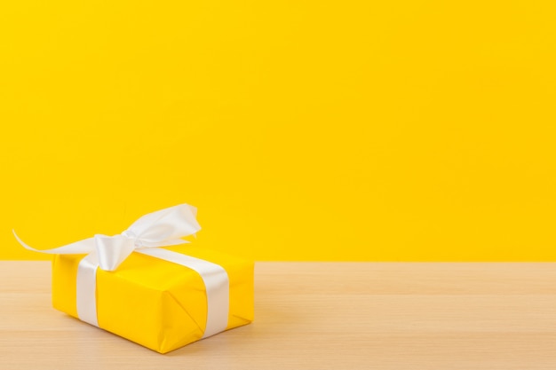 Gifts with ribbons on bright yellow background