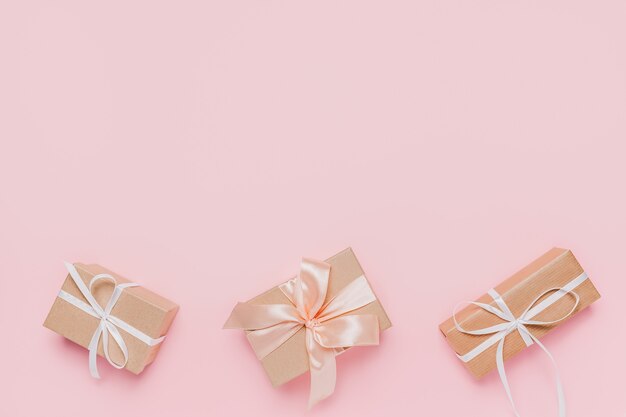 Gifts with wihte ribbon on isolated pink background, love and valentine concept