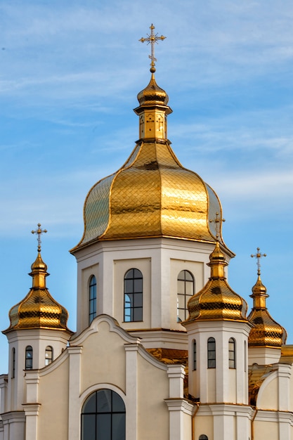 Фото Позолоченные купола православной церкви светятся на фоне голубого неба