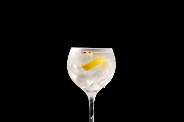 Cocktail gin tonic drink in un bicchiere su sfondo nero