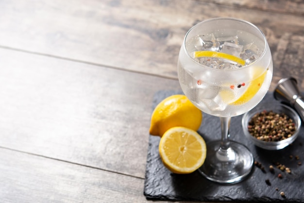 Gin tonic cocktail drink into a glass on wooden table Copy space