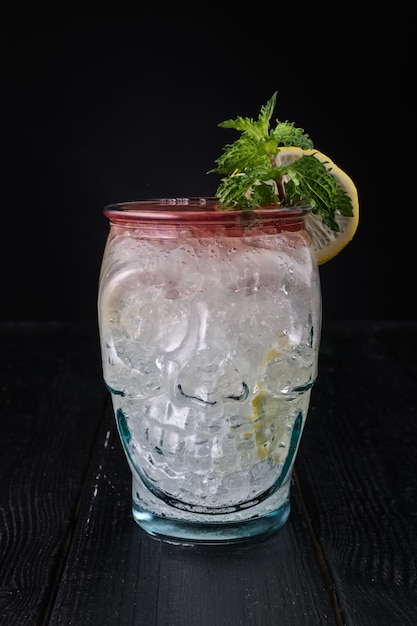 Gin and tonic cocktail with cherry syrup in skull cup