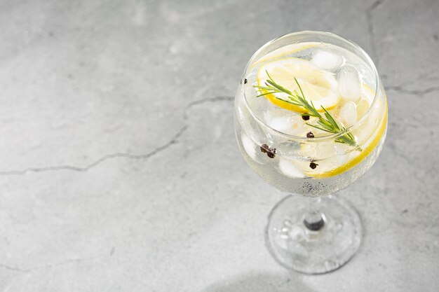 Gin Tonic garnished with lemon and rosemary