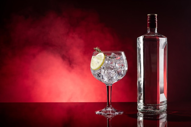 Photo gin tonic on red background with smoke with copyspace