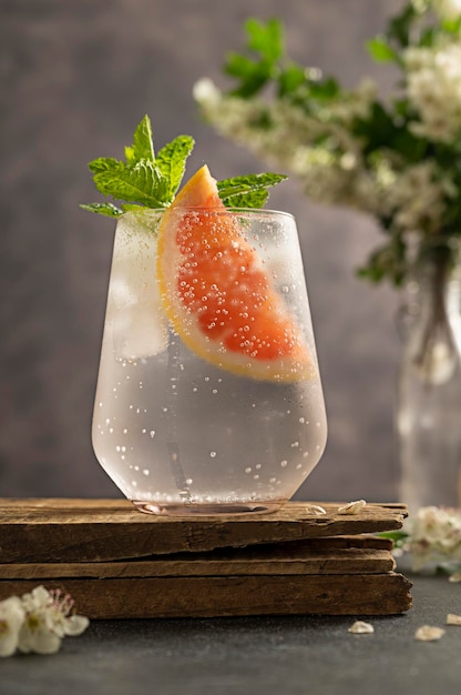 Gin-tonic verfrissende zomerdrank grapefruitcocktail met bloeiende brunch op achtergrond