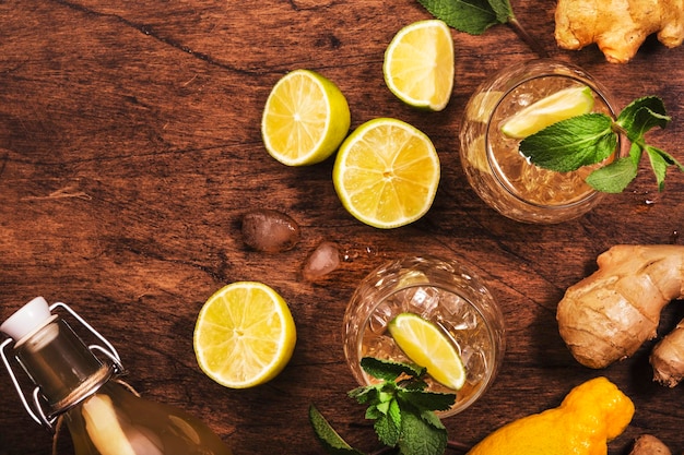 Ginger ale cocktail con birra lime limone e menta in vetro su tavolo in legno vista dall'alto