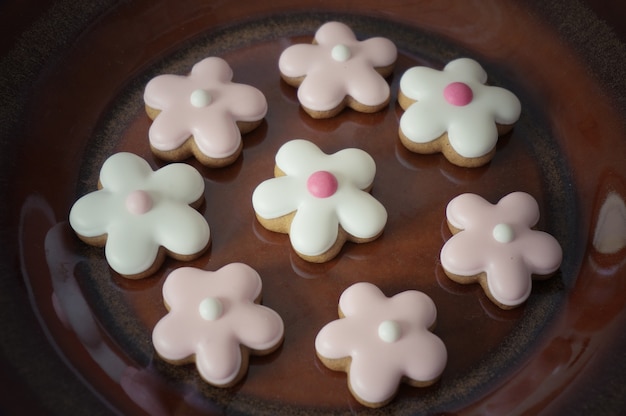 Ginger cookies flower shape on brown ceramic plate