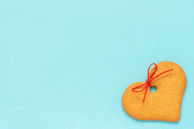 Ginger cookies heart-shaped decorated with a bow on a blue background