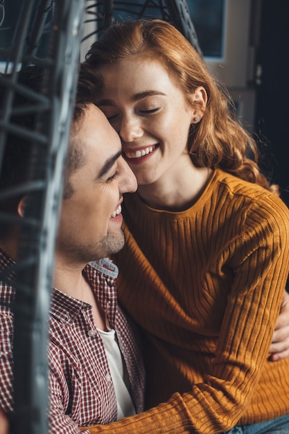 Ginger freckled lady and her lover are having a date on valentines day embracing and smile together