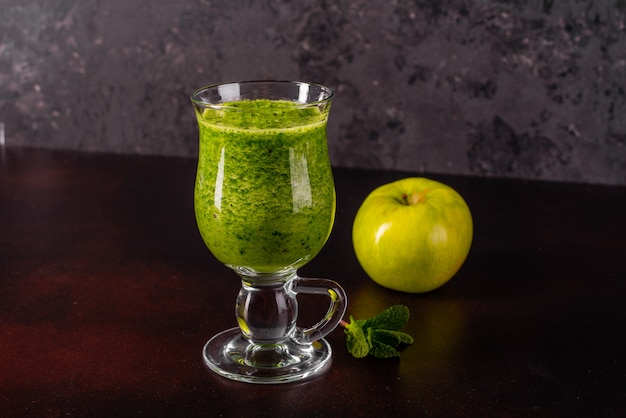 Ginger green apple smoothie on concrete background.