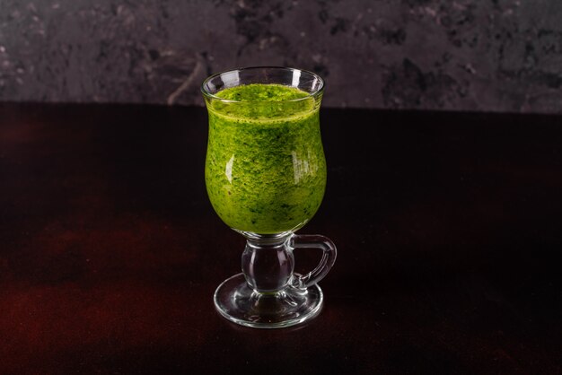 Ginger green apple smoothie on concrete background.