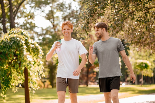 Ginger guy with drink and dark-haired guy after running