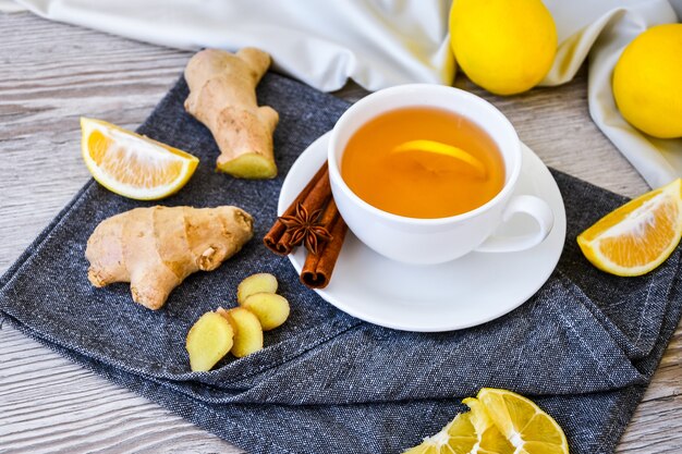 ginger hot immunity boosting vitamin natural drink with citrus lemon cinnamon anise in a rustic style on wooden background. chamomile tea. healthy concept