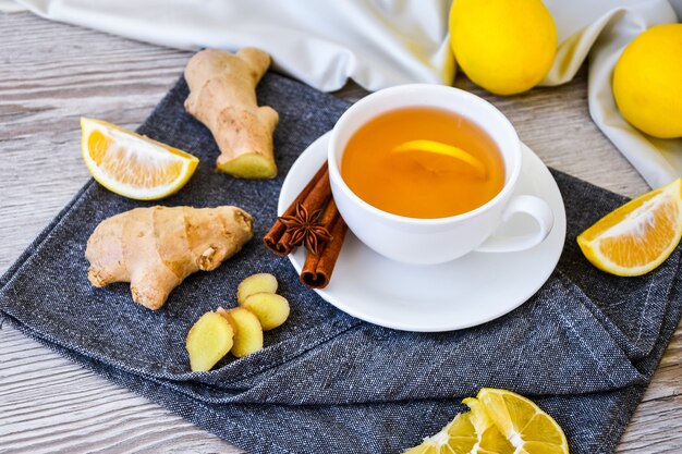 Ginger hot immunity boosting vitamin drink natural drink con agrumi, limone, cannella, anice in stile rustico su fondo di legno. tè alla camomilla. concetto sano