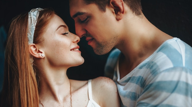 Ginger lady with freckles and her brunette lover kissing and spending time together