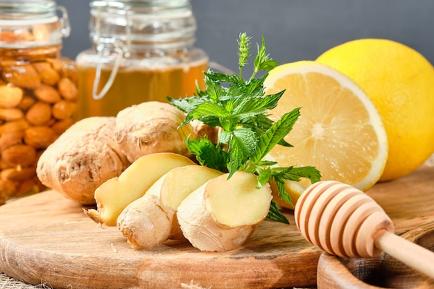 Ginger, lemon and mint on a wooden board with honey and nuts