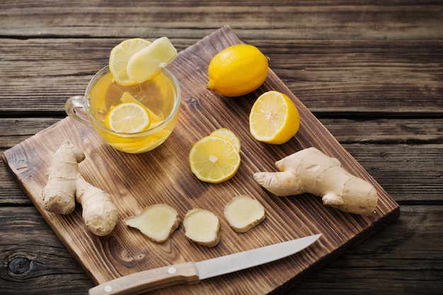 Ginger and lemon tea on wooden background