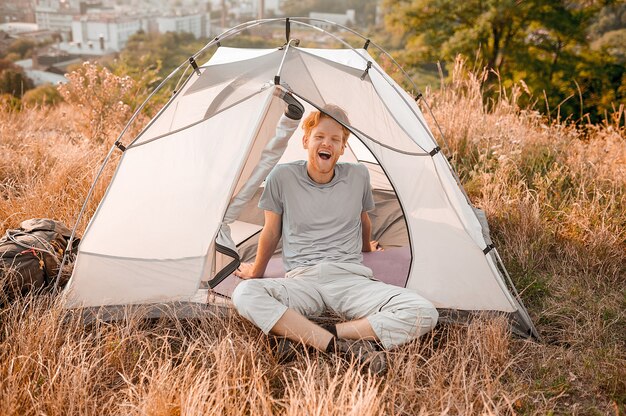 A ginger man sitting in the tent and feeeling sleepy