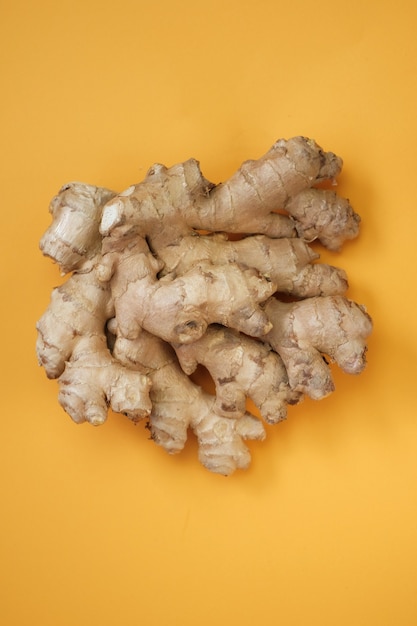 Photo ginger root closeup on a yellow wall organic bio healthy vegetables and spices