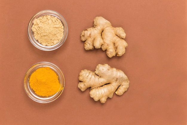 Photo ginger root dry ginger turmeric and rosemary sprig brown background