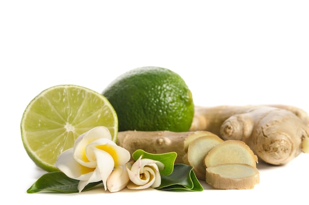 Ginger root and lime whole and half with flowers and leaves isolated on white background