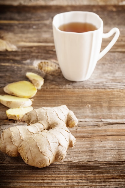 Ginger tea in a white cup on wooden table