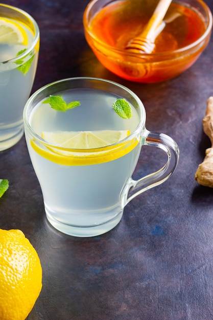 Ginger tea with lemon and mint on glass mugs