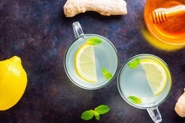 Ginger tea with lemon and mint on glass mugs